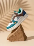 Lifestyle view of multicolor casual sneaker for men with teal, tan, white and navy panels on chunky off‑white sole.